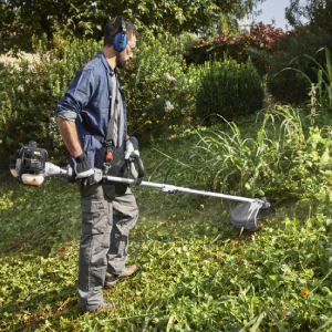 Operatore con abbigliamento tecnico che taglia erba alta con decespugliatore Alpina